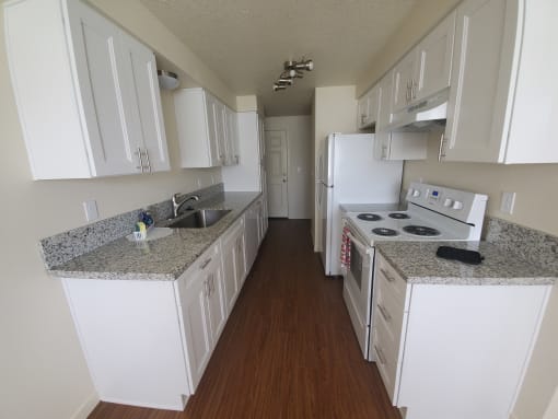 a kitchen with white cabinets and granite countertops