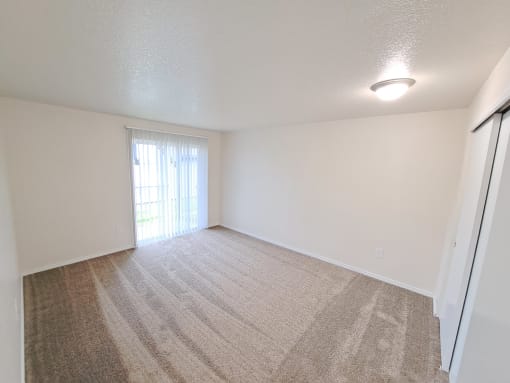 a bedroom with a sliding glass door and a carpeted floor