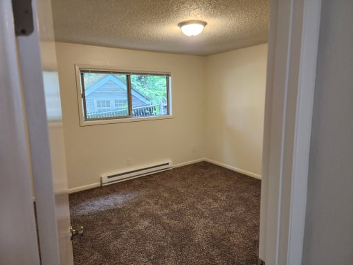an empty room with carpet and a window