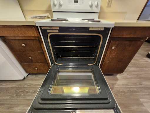 A modern oven with a glass door is open in a kitchen.