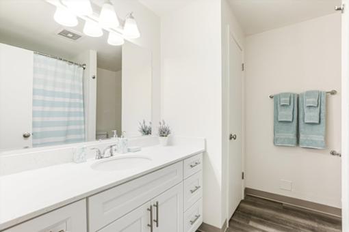 A bathroom with a white sink and a mirror above it.