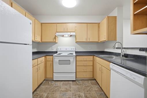 A kitchen with a white refrigerator and a white stove top oven.