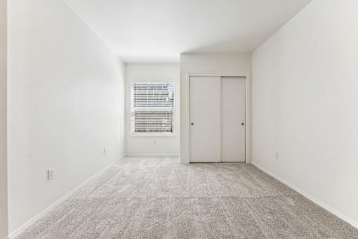 A room with a carpeted floor and a door.