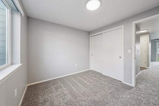 A room with a carpeted floor and a white door.