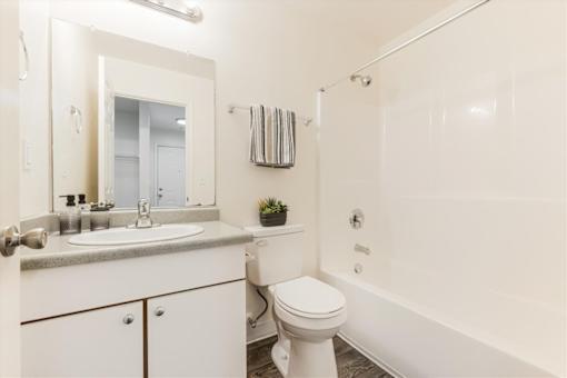 A white bathroom with a toilet, sink, and bathtub.