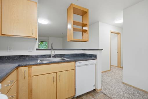 A kitchen with wooden cabinets and a black countertop.