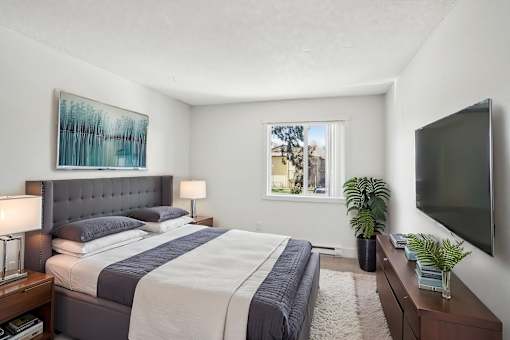 A bedroom with a large bed and a painting on the wall.
