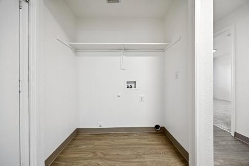 A room with a white wall and a wooden floor.