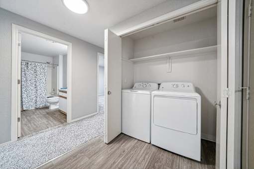 A white laundry room with a washer and dryer.
