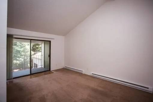 A room with brown carpet and white walls.
