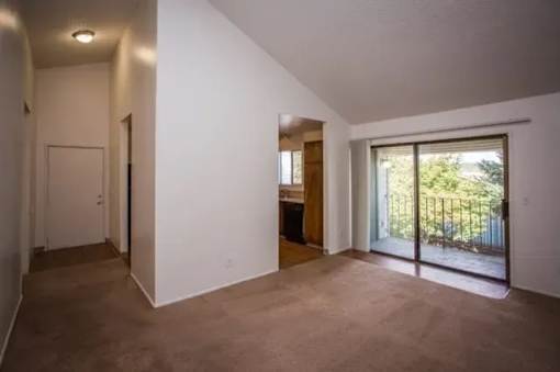 A room with a sliding glass door leading to a balcony.