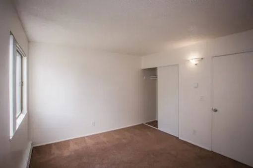 A room with white walls and a brown floor.