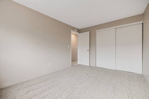 A room with a carpeted floor and a white door.