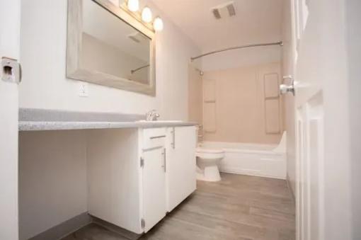 A white bathroom with a toilet, sink, and bathtub.