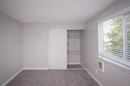 A room with a white door and a window with blinds.