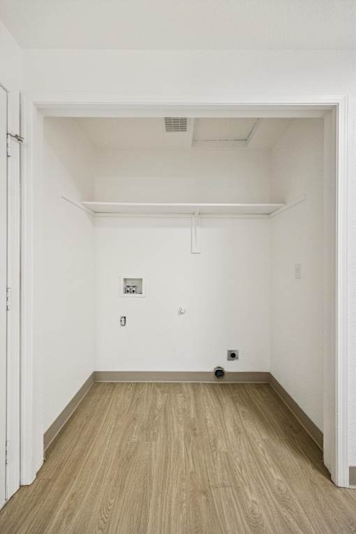 A room with a white wall and a brown floor.