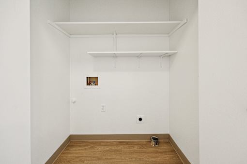 A room with a wooden floor and a picture frame on the wall.