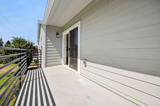 A house with a grey siding and a glass door.