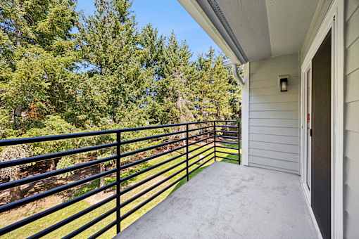 A balcony with a black railing and a white door.