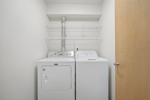 A white washing machine and dryer in a small laundry room.