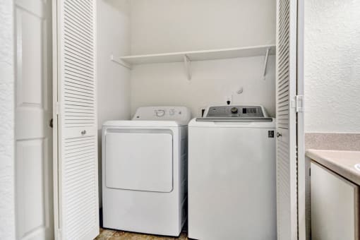 a washer and dryer in a laundry room with a door open