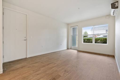 A room with a white door and a window with a view of the outside.
