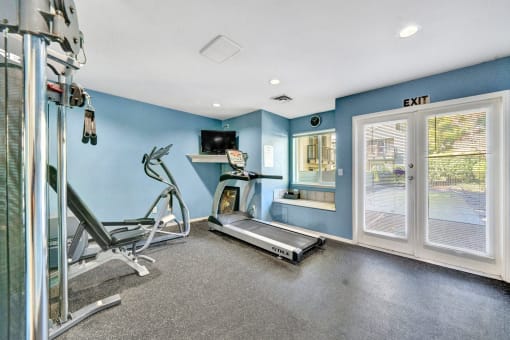 the gym has plenty of cardio equipment and a window