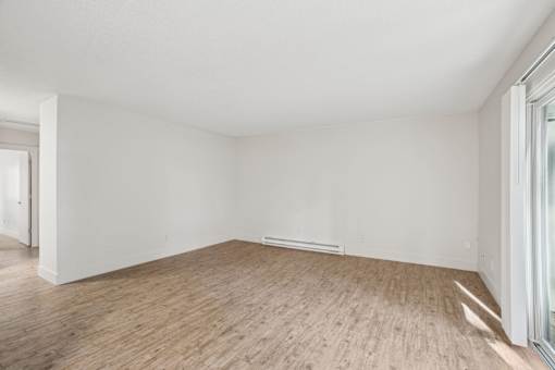A room with wooden flooring and white walls.