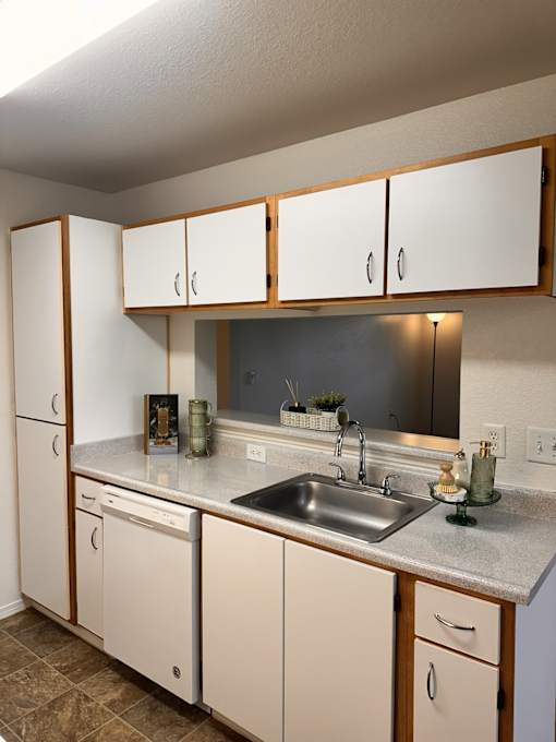 A kitchen with white cabinets and a sink.