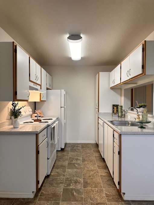 A kitchen with white cabinets and a tiled floor.