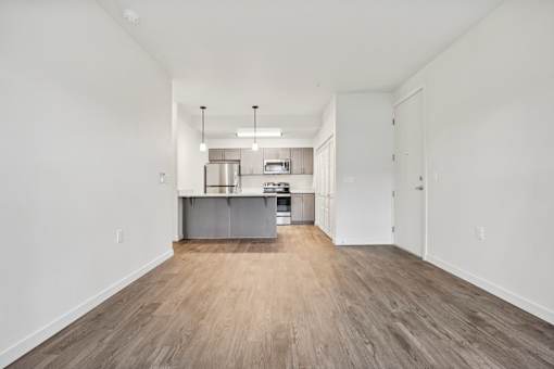 A kitchen with white walls and wooden floors.
