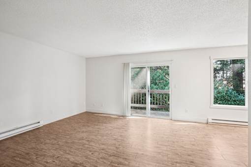 Empty room with a sliding glass door leading to a balcony.