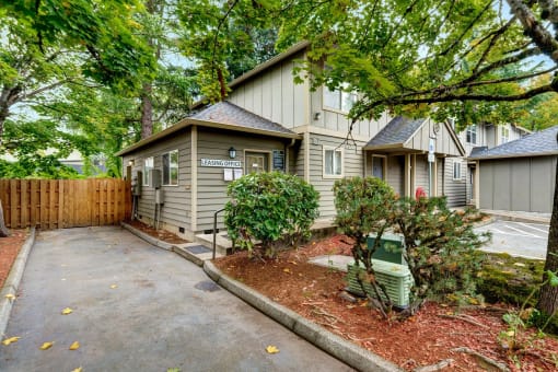 a small house with a driveway and a yard in front of it