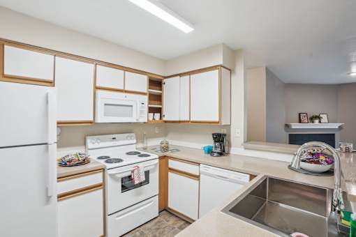 A kitchen with white appliances and wooden cabinets.