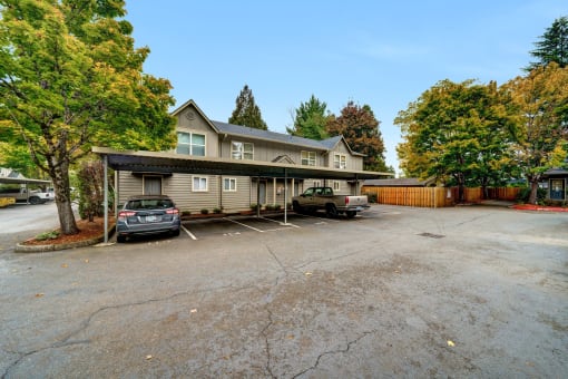 a house with a parking lot and cars in front of it