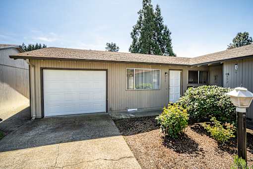 A house with a white garage door and a brown roof.