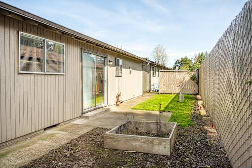 A backyard with a fence and a small garden.
