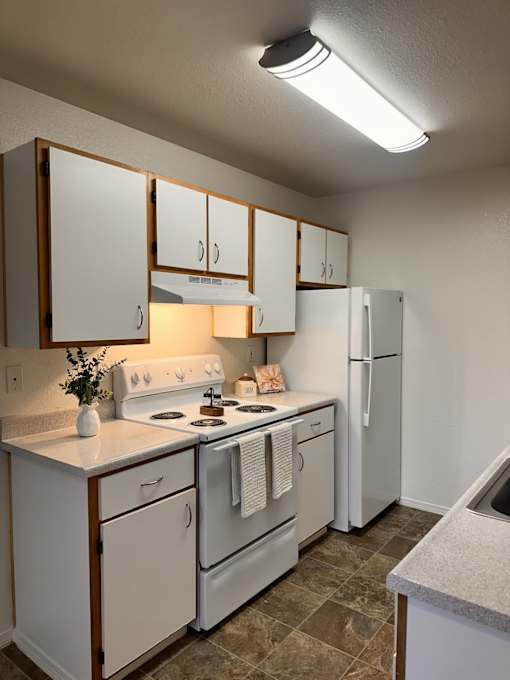 A kitchen with white appliances and cabinets.