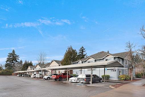 A parking lot with cars and a building in the background.