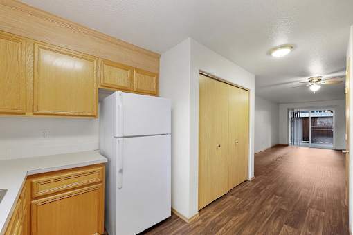 A kitchen with wooden cabinets and a white refrigerator.