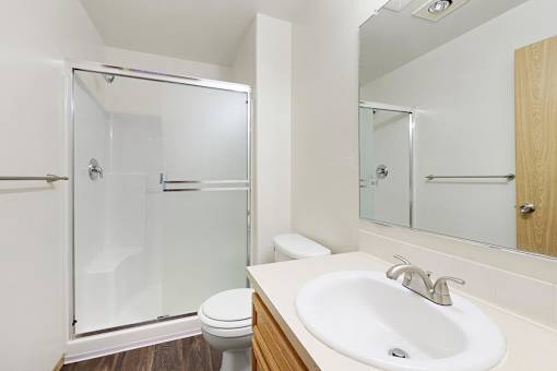 A white sink is on a countertop next to a toilet.