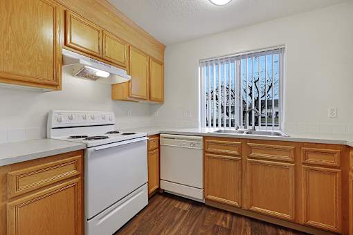 A kitchen with wooden cabinets and white appliances.