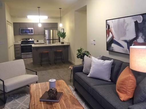 A modern living room with a grey couch and a wooden coffee table.