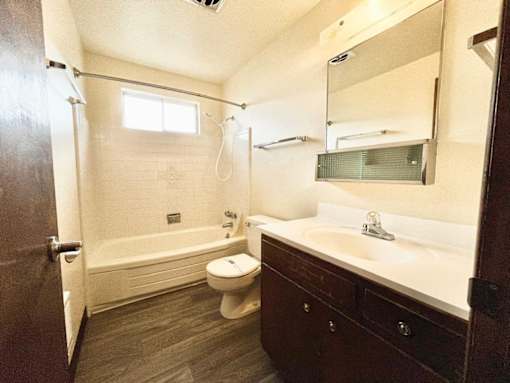 A bathroom with a toilet, sink, and bathtub.