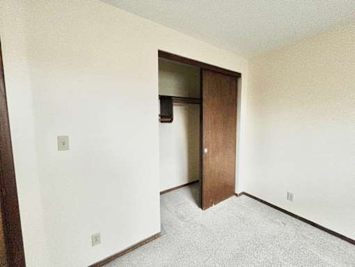 A room with a white wall and a brown door.