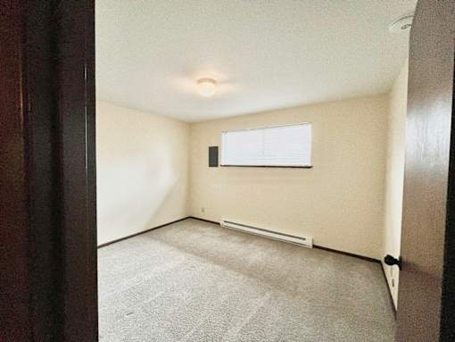 A room with a window and a white radiator on the wall.