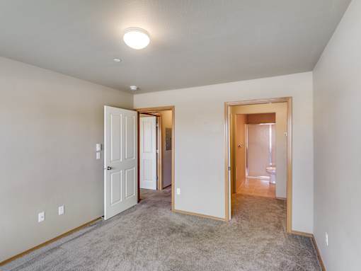 A room with a carpeted floor and a white door.
