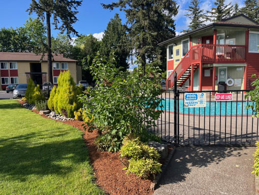 a house with a pool and a fence in front of it