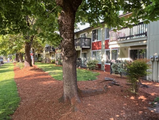 an apartment building with trees and grass in front of it