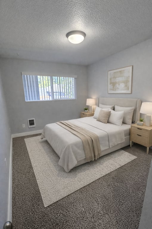 A bedroom with a bed, nightstand, and window.